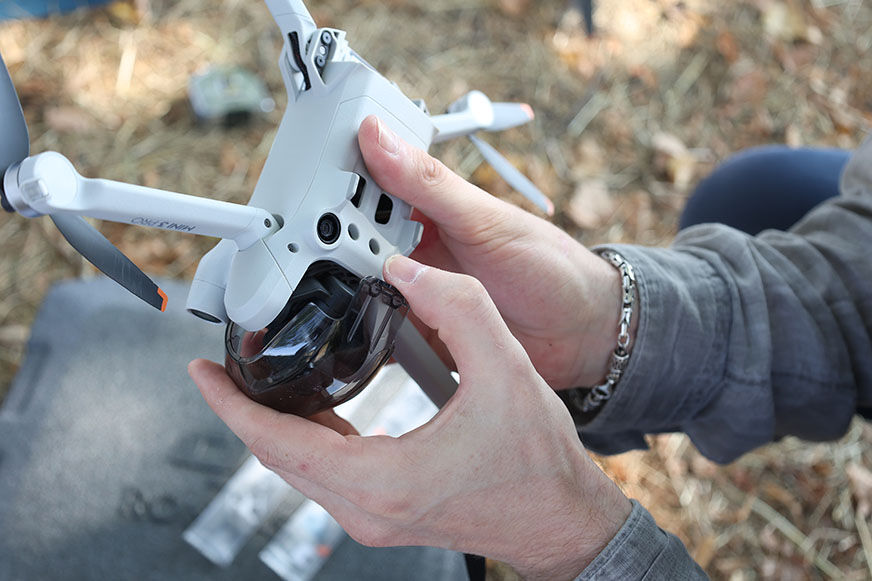 Die Schutzkappe des Gimbals wird von der DJI MIni 3 Pro heruntergenommen.